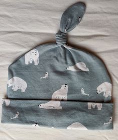 "Perfect for that special little someone in your life- cute little polar bears on a darling little top knot hat.  It's soft, it's stretchy, it's cozy.  It's also simply stinkin' cute.  Made with jersey knit fabric (95% polyester, 5% spandex), it has some stretch to it. It's lightweight and great for those days where your little one needs some extra warmth! All seams are serged for a finished look. The fabric has been pre-washed. Circumference of the hat is 14-16\", would fit 0-3 month olds the b Cute Soft Adjustable Hats, Cute Soft Hats For Gifts, Cute Soft Hats Perfect As Gifts, Cute Warm Cotton Hat, Polar Bears, Gender Neutral Baby Clothes, Jan 17, Jersey Knit Fabric, Top Knot