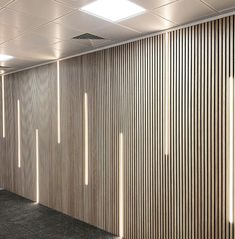 an empty room with wooden slats on the wall and carpeted flooring in front of it