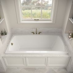 a large white bath tub sitting under a window