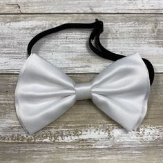 "Adults/Teens Elastic Suspender, Bow-tie All dimensions are approximate only Suspender Dimensions: Wide : 1.5\" (3.81cm) Adjustable from 25\" 63.5cm - 38\" (96.52cm) Bow Tie Dimensions: Length: 12cm (4.7 inches) Height (Widest Point): 6cm (2.36 inches) Height (Narrowest Point): 2.3cm (0.90 inches) Length of Bow Tie Strap at full length: 48cm (18.89 inches)" Classic White Bow With Ribbon, Adjustable White Satin Bow, White Bow Tie For Black-tie Events, Fitted Pre-tied Tie For Party, White Bow Tie For Black Tie Events, Fitted Pre-tied Bow For Party, Formal White Bow Tie With Butterfly Knot, White Formal Bow Tie With Butterfly Knot, Formal White Bow Tie With Ribbon