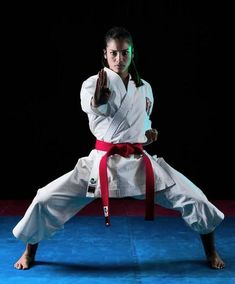 a woman is doing karate on a blue mat