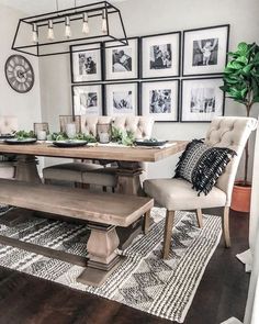 a dining room table with chairs and pictures on the wall above it, along with an area rug