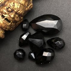 some black stones on a table next to a gold statue