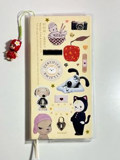 a book with stickers on it sitting next to a keychain and other items