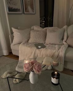 a living room with a couch, coffee table and candles on the floor in front of it