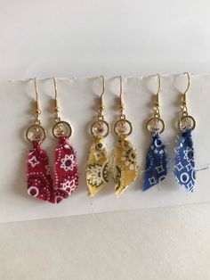 These earrings are handmade with a piece of bandanna fabric in there different colors red, blue, and yellow. Each earring has a small charm hanging in the gold colored circle. These earrings are very light weight and measure approximately 2 1/4 inches long from the earring hook to bottom of fabric. If you have any questions or concerns feel free to contact owner and designer at hannahsjeweltique@gmail.com Attention: color may look different on your electronic device than another Hanky Code, Western Earrings, Earring Hook, Jewelry Techniques, Small Charms, Ear Rings, Fabric Jewelry, Blue And Yellow, Earring Necklace