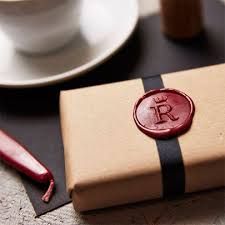 a waxed seal sits on top of a brown box next to a cup and saucer