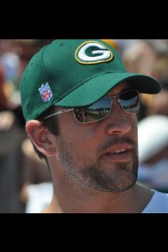 a man wearing sunglasses and a green bay packers hat