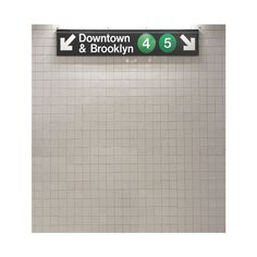 a subway sign on the wall pointing to downtown and brooklyn, with arrows pointing in different directions