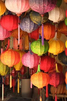 many different colored paper lanterns hanging from the ceiling