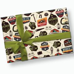 a gift wrapped in green ribbon and surrounded by stickers