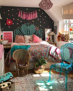 a bedroom decorated in pink, blue and white with lots of decorations on the wall