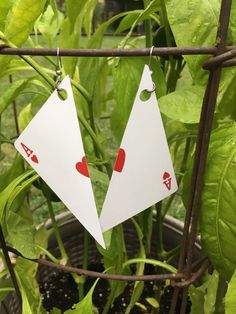 pair of playing cards earrings hanging from plant