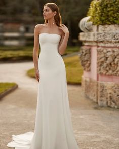 a woman in a white wedding dress posing for the camera