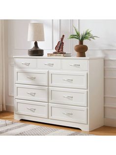 a white dresser with two lamps on top of it