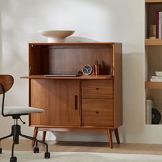 a desk with a chair next to it and bookshelf in the back ground