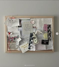 a bulletin board covered in lots of papers and magnets on top of a wall