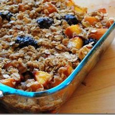 a casserole dish filled with oatmeal and fruit sitting on a wooden table