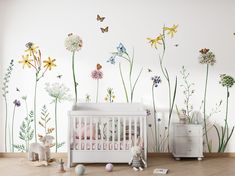 a baby's room with flowers and butterflies on the wall