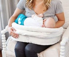 a woman sitting in a chair holding a baby while wearing a blue and white diaper