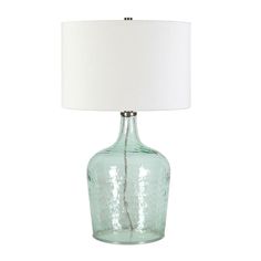 a green glass table lamp with a white shade on the base and a white fabric lampshade