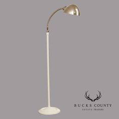 a white floor lamp with an antelope head on the side and buck's country logo above it