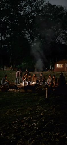 a group of people sitting around a campfire