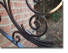 an iron gate is shown in front of a brick wall