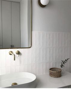 a bathroom with a sink, mirror and basket on the counter