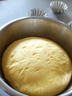 a metal bowl filled with dough on top of a table