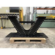 a large metal letter sitting on top of a wooden pallet in a factory room