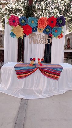 the table is decorated with paper flowers and ribbons