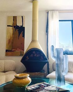 a living room with a glass coffee table and a wood burning stove in the corner