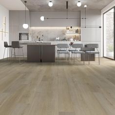 an open kitchen and dining area with wood flooring, white walls and grey chairs