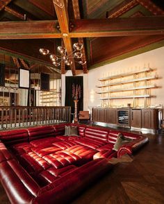 a large red leather couch sitting inside of a living room