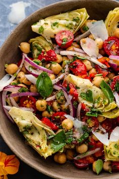 a bowl filled with salad and garnishes on top of a blue table