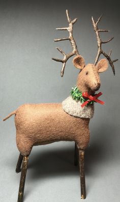 a deer made out of felt with antlers on it's head and scarf around its neck