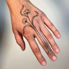 a person's hand with a flower tattoo on it