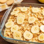 a casserole dish with banana slices and granola in it on a wooden table