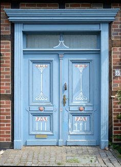 two blue doors with decorative designs on the front and side of each door are shown