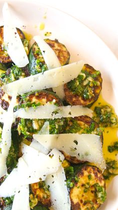 a white plate topped with grilled eggplant and parmesan cheese