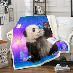 a panda bear with butterflies on it's back is sitting in a chair under a purple and blue blanket