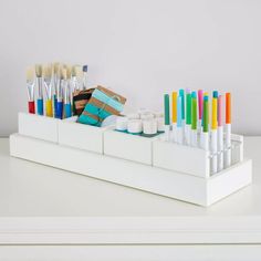 an assortment of paint brushes and tubes in a holder