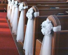 rows of pews decorated with white flowers and ribbons