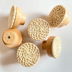 four wooden knobs with woven handles on a white surface, one has a button in the middle