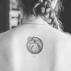 a black and white photo of a woman with a cat tattoo on her upper back