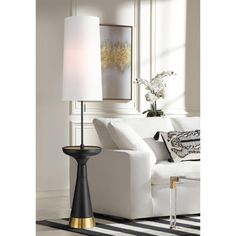 a living room with a white couch and black table lamp