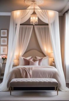 a bed with white drapes and pink pillows