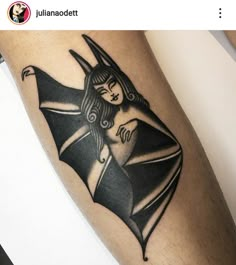 a black and white tattoo on the leg of a woman with a bat in her hand