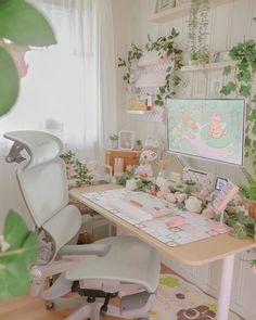 a desk with a chair, computer monitor and plants in the corner next to it